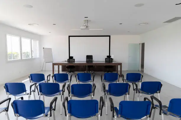 Bright modern meeting room with blue chairs and white walls.