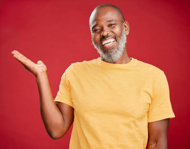 istock Mature african american man with a beard smiling and making a hand gesture standing against a red studio background. Happy, smiling, showing 1417035616