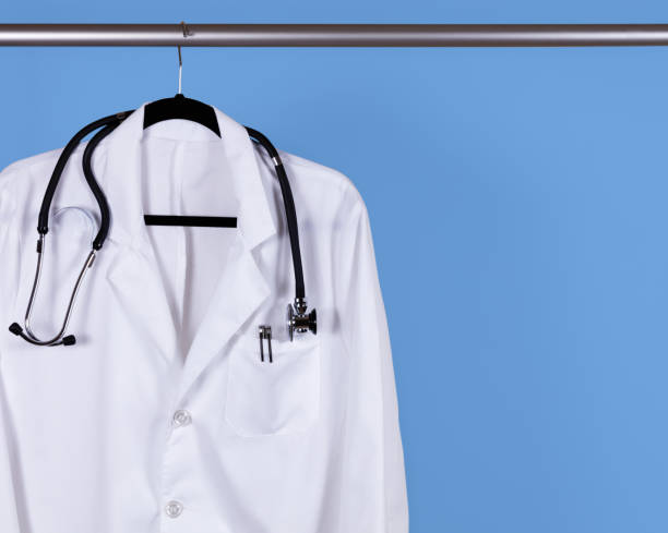 istock Medical white jacket hanging on blue wall 1417035719