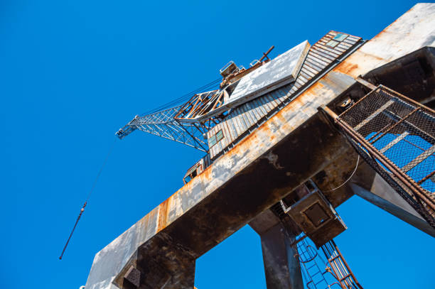 istock Disused rusting crane machinery viewed from below against a clear blue sky 1417036124