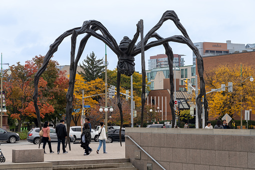 Ottawa, Ontario, Canada - October 16 2021 : Maman (sculpture) at the National Gallery of Canada. People walking on the street in autumn season.