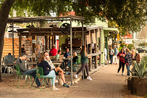 Austin, Texas, USA - November 15, 2021:  People walk along the trendy South Congress Street colourful shops and cool restaurants in Austin Texas USA.  This fashionable area is an increasingly popular shopping and dining district and serves as a creative hub.
