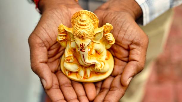 ręce trzymające idola lorda ganeshy w tle dłoni dla visarjan lub immersion. coroczny rytuał idola pana ganapati podczas hinduskiego festiwalu ganesh chaturthi z promieniami słonecznymi. ganesh utsav w mieście radżastan w indiach - happy group zdjęcia i obrazy z banku zdjęć