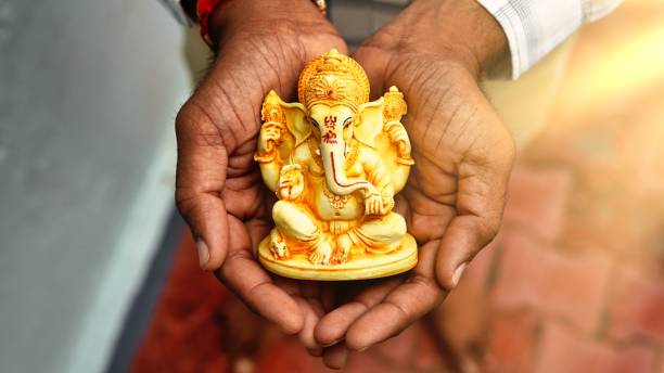 ręce trzymające idola lorda ganeshy w tle dłoni dla visarjan lub immersion. coroczny rytuał idola pana ganapati podczas hinduskiego festiwalu ganesh chaturthi z promieniami słonecznymi. ganesh utsav w mieście radżastan w indiach - happy zdjęcia i obrazy z banku zdjęć