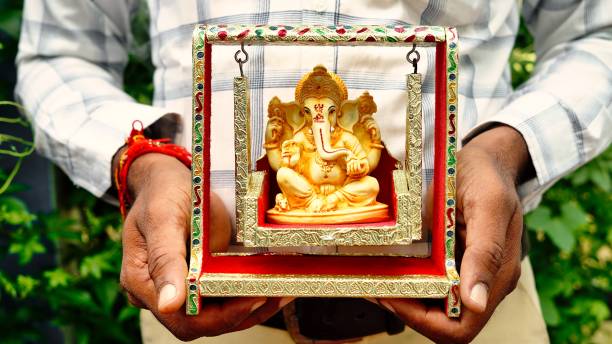 ręce trzymające idola lorda ganeshy w tle dłoni dla visarjan lub immersion. coroczny rytuał idola pana ganapati podczas hinduskiego festiwalu ganesh chaturthi z promieniami słonecznymi. ganesh utsav w mieście radżastan w indiach - happy group zdjęcia i obrazy z banku zdjęć