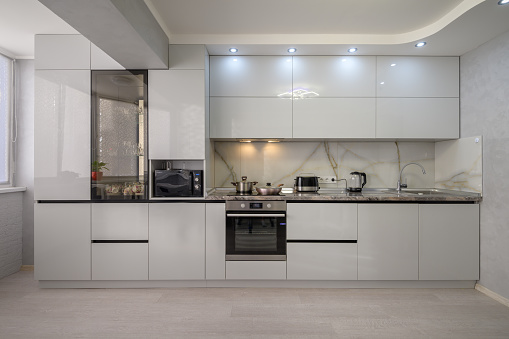 Luxury Modern Kitchen Interior With White Cabinets, Kitchen Island And Tiled Floor