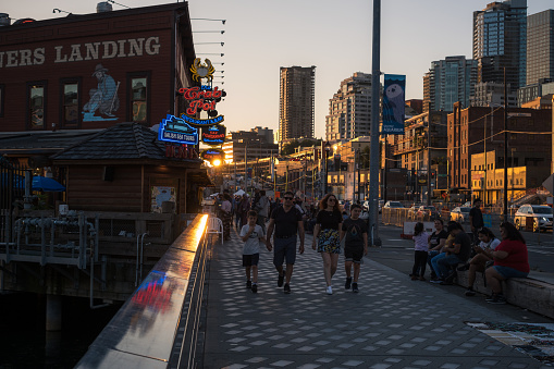 Seattle, USA - Aug 2, 2022: Travelers late in the day on the waterfront.