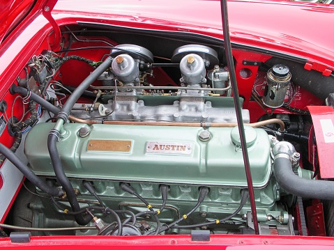 The classic inline 6 cylinder engine of an Austin Healey at the Moncton British car show. The timeless classic roadster of a 50 year old automobile.