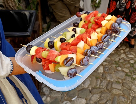 Fruit skewers appetizers made of plums, watermelon, melon, white grapes, apple and red grapes in a serving tray