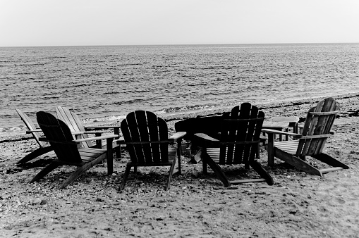 4 low chairs by the sea around a table in half circle
