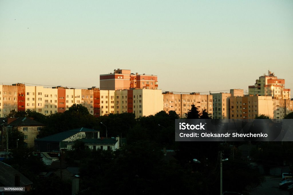 View of the city from the window of the apartment. Sunset in the city and the view from the window. Houses, trees in the city at sunset Aerial View Stock Photo