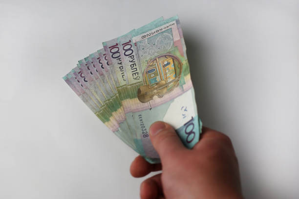 istock Give, take, banknotes of Belarusian rubles in a hand on a gray background 1417051332