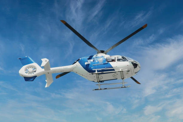 helicóptero de rescate de ambulancia aérea azul y blanco volando en el aire sobre un fondo de cielo azul - helicóptero fotografías e imágenes de stock