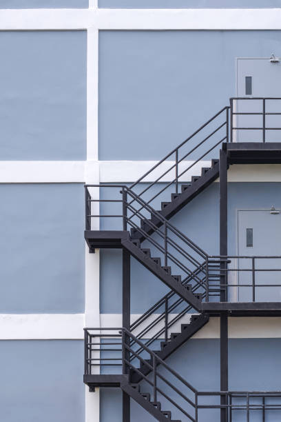 fundo de escada de incêndio de aço preto na parede de construção cinza e branco em construção - black ladder white staircase - fotografias e filmes do acervo