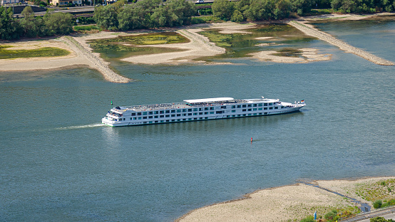 River cruise ship in the Middle Rhine Valley at low tide in summer 2022, sandbanks in the background