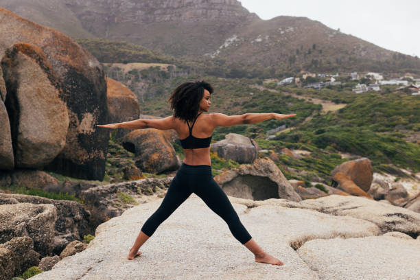 istock Barefoot woman practicing yoga exercises outdoors while standing on a big rock 1417064275