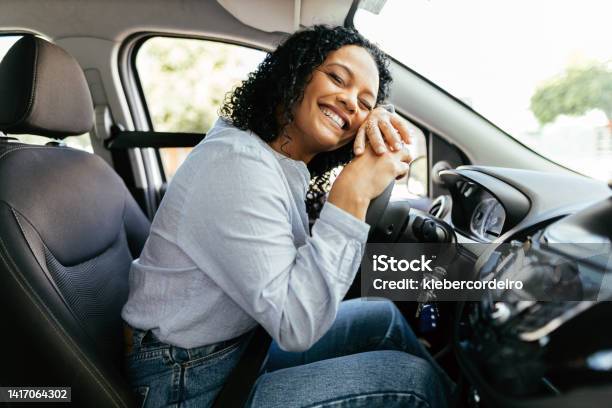 Young And Cheerful Woman Enjoying New Car Hugging Steering Wheel Sitting Inside Woman Driving A New Car Stock Photo - Download Image Now