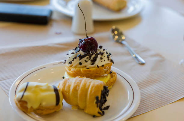 白い皿にチェリーベリーが乗った3つの小さなケーキのクローズアップビュー。 - unhealthy eating cherry chocolate close up ストックフォトと画像