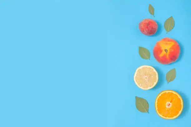 Blue summer background with tropical fruits - creative minimal composition