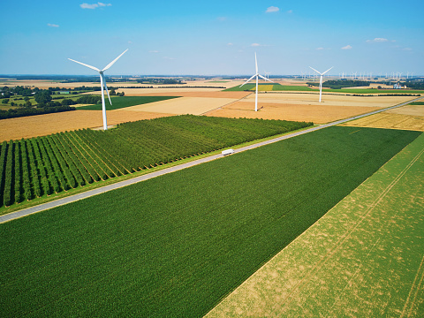 Scenic aerial drone view of wind turbines and green and yellow fields in Normandy, France