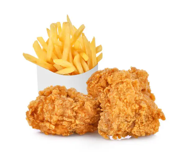 Photo of French fries in a white paper box and fried chicken isolated on white