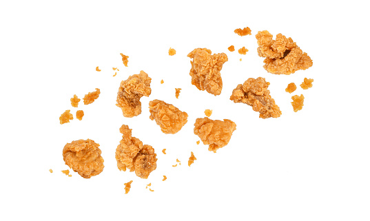 Fried popcorn chicken falling in the air isolated on white