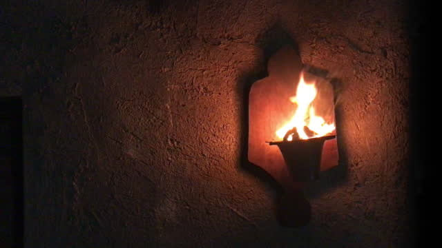 flaming torch on a cob wall