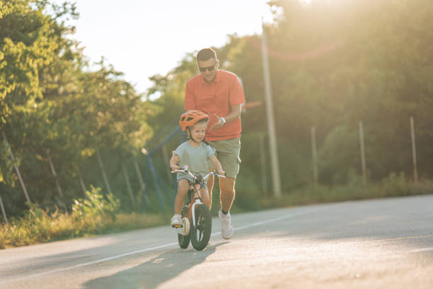 istock Father teaching his daughter to ride a bicycle 1417075949