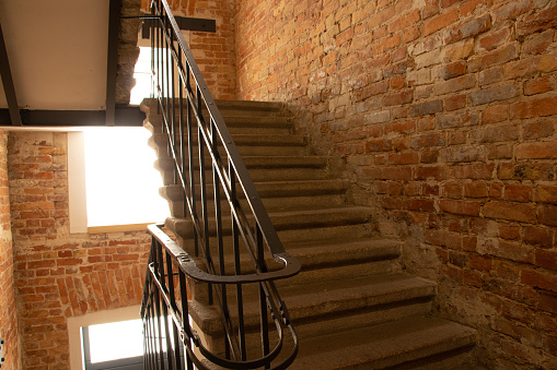an entrance inside an old house with a staircase to the top and brick walls in Ukraine, a stairway in a multi-storey old house, a staircase in the house