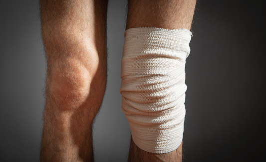Bandage on injured knee. First aid and medicine concept