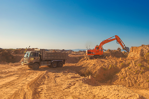 An Excavator on work with Loader Truck