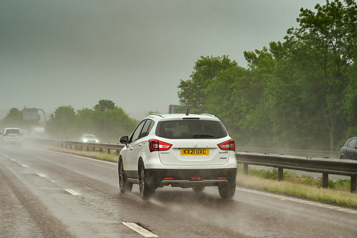 Swindon, England - May 2022: Traffic on the M4 motorway in bad weather with spray from cars and poor driving conditions and visibility