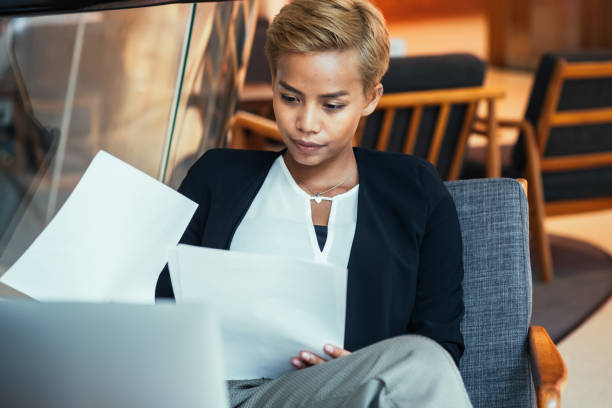 istock Smiling Businesswoman Reading Documents In The Cafe 1417080821