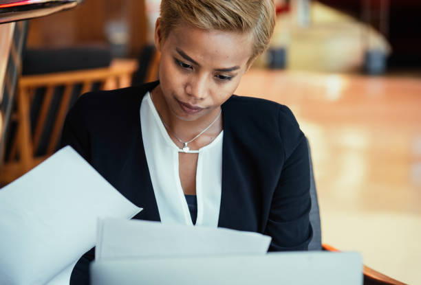 istock Smiling Businesswoman Reading Documents In The Cafe 1417080828