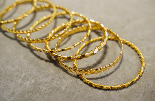 Large group of gold bracelets on jewelry display