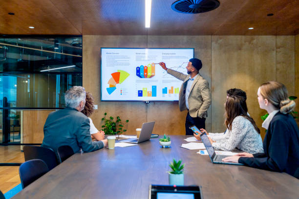 istock Man giving a big data presentation on a tv in a board room. 1417094376