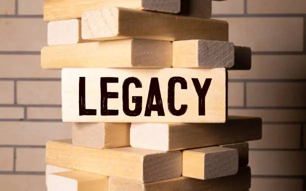 Photo of LEGACY concept, wooden word block on grey background