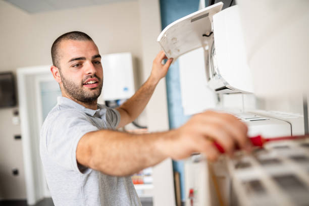 Repairman changing filter on air conditioner stock photo