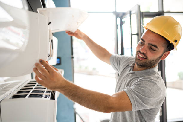 Technician cleaning air conditioner filter stock photo