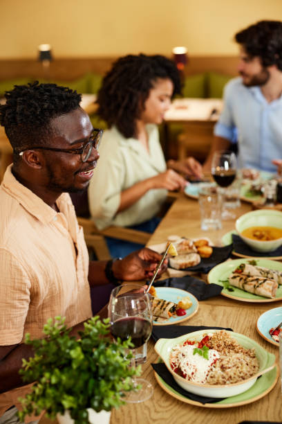 istock A multicultural man is having dinner with friends in a restaurant. 1417108738