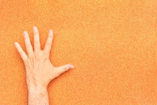 istock man hand upside down on glitter orange background left handed 1417110024