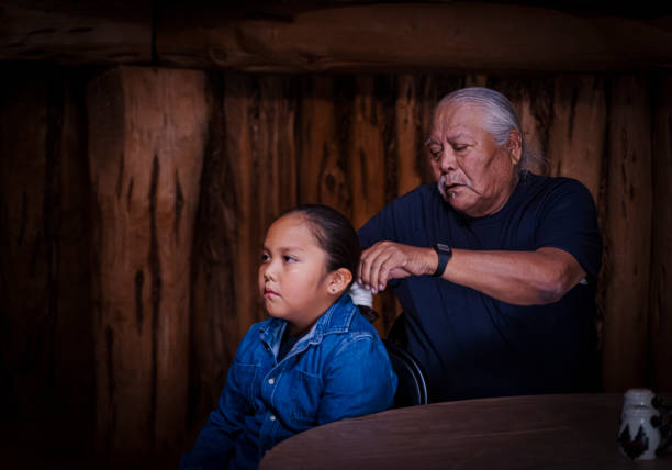 el abuelo trenzando el cabello de su nieto de la manera tradicional - navajo national monument fotografías e imágenes de stock