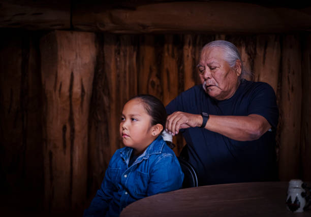 grand-père tressant les cheveux de son petit-fils de manière traditionnelle - navajo national monument photos et images de collection