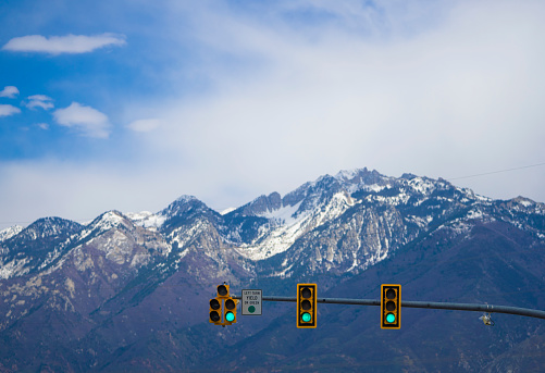A traffic light in front of snowcapped mountains in Utah, USA