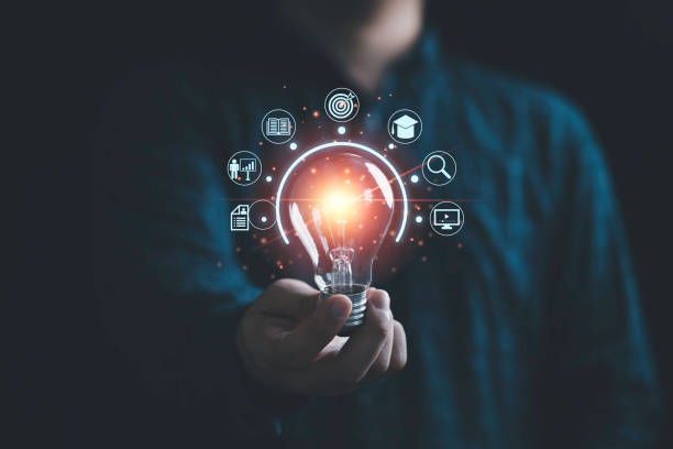 istock Businessman holding glowing lightbulb with learning icons for study knowledge to creative thinking idea and problem solving solution concept. 1417125144