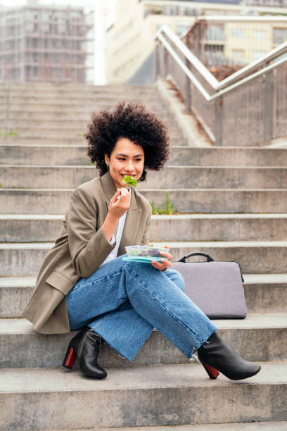 istock woman eating a salad during a break from work 1417142590