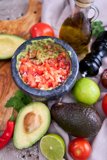 istock making guacamole - crushed avocado in marble mortar and ingredients 1417143514