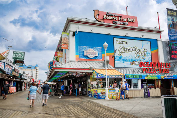 Tourists at the Shops in Ocean City, Maryland Ocean City, MD/USA - August 2, 2022: Tourists walk along the shops, attractions and food establishments on the boardwalk at Ocean City, Maryland in the summer boardwalk stock pictures, royalty-free photos & images