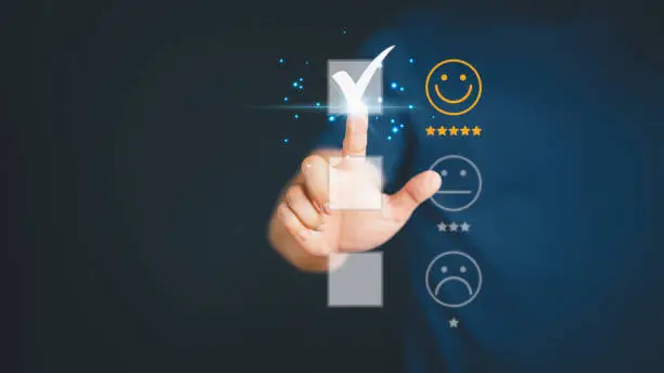 Photo of Man touching the virtual screen on the happy smiley face icon to give satisfaction in service. Rating very impressed. Customer service and satisfaction concept.