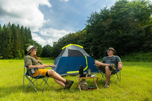 istock Couple camping together in wide lush grass field 1417183828